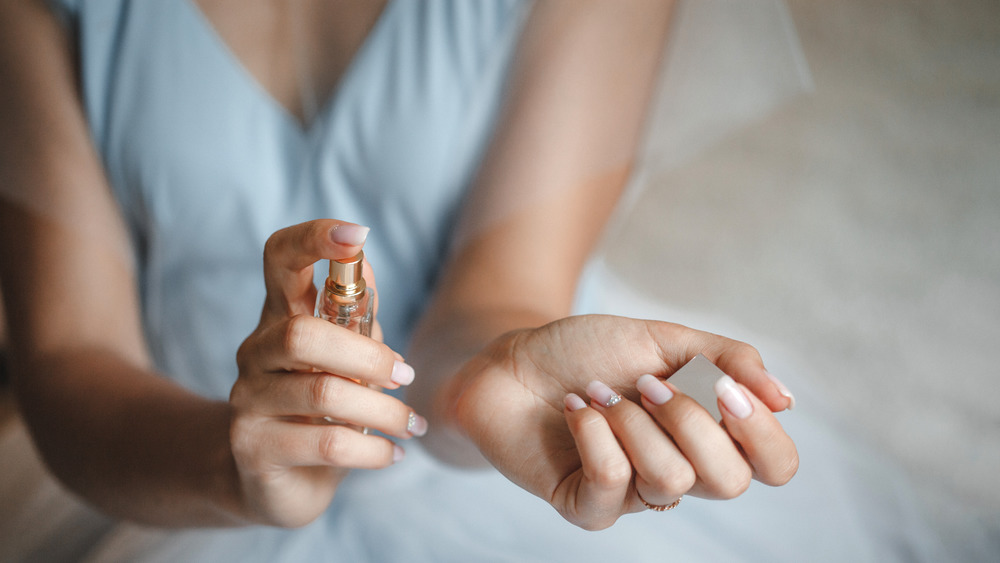 Woman spraying perfume