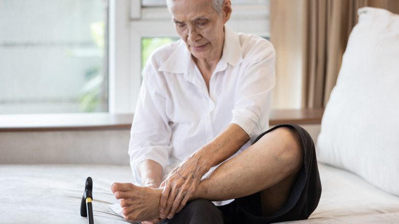 senior man holding sore foot