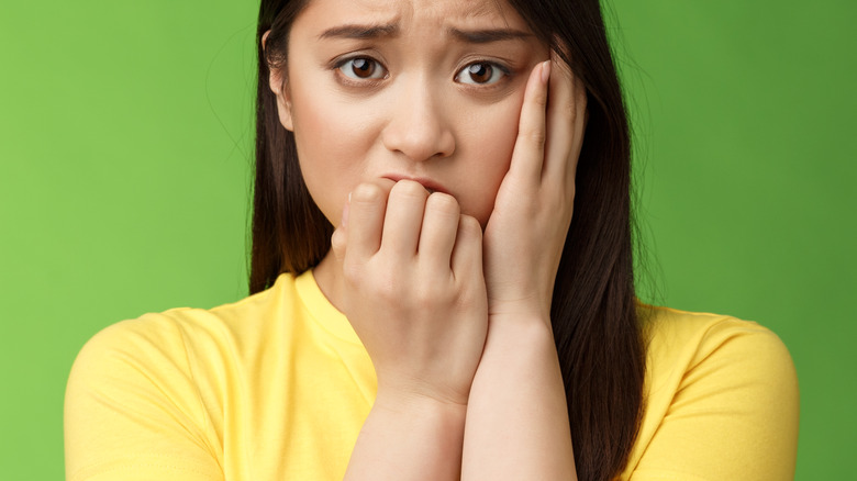 a stressed out woman in a yellow t-shirt