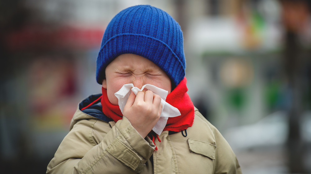 Little boy blows his nose