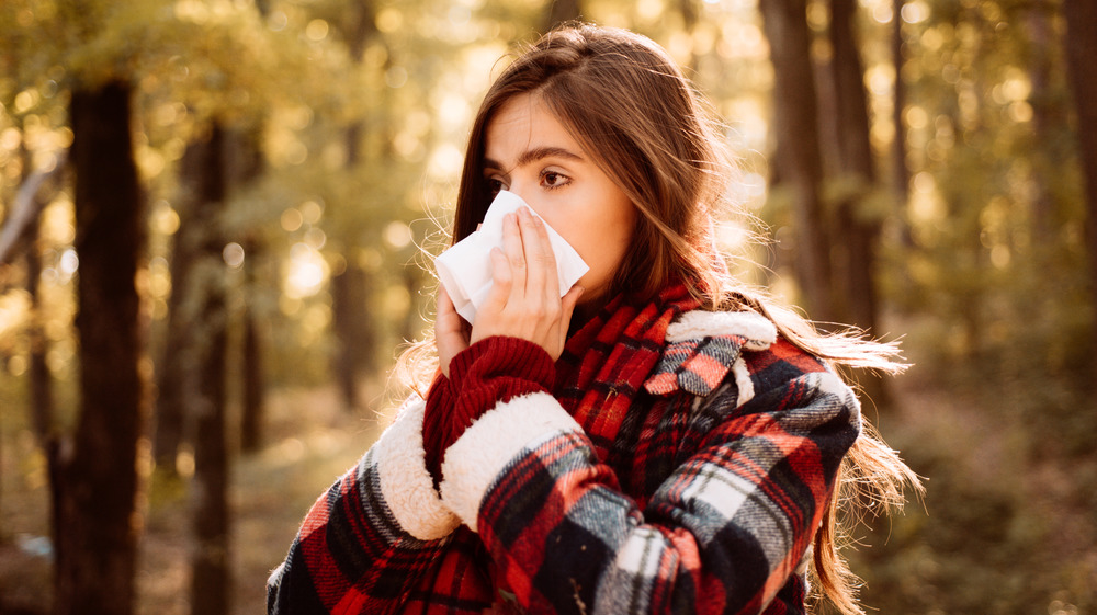 Woman outside blows her nose