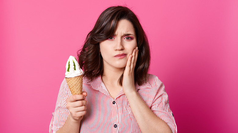 woman eating ice cream and holding jaw