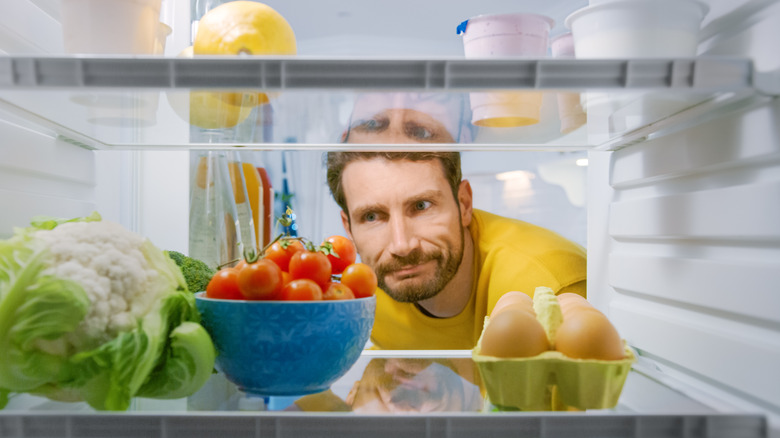 A man searching the refrigerator