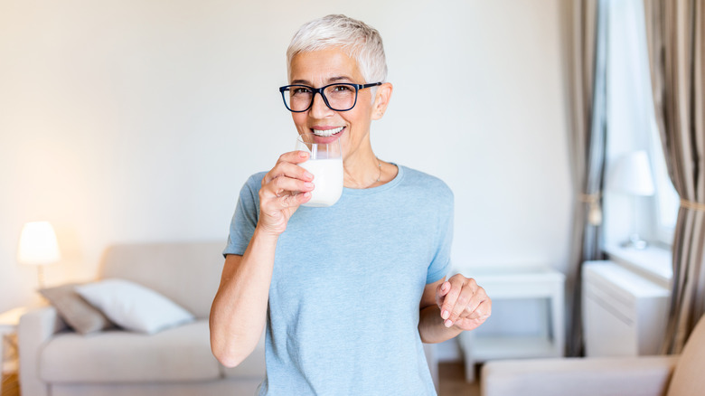 Woman holding a glass of milk.