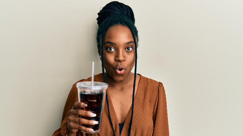 woman holding cup of soda