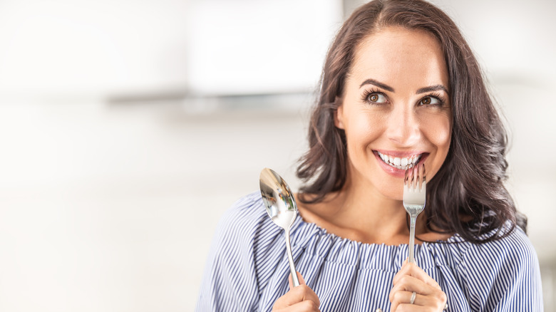 a hungry woman with a fork and spoon
