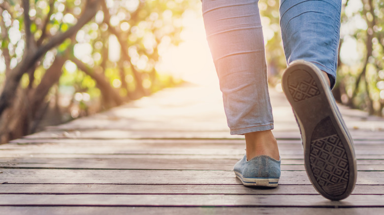 Woman walking on small wood bridge 
