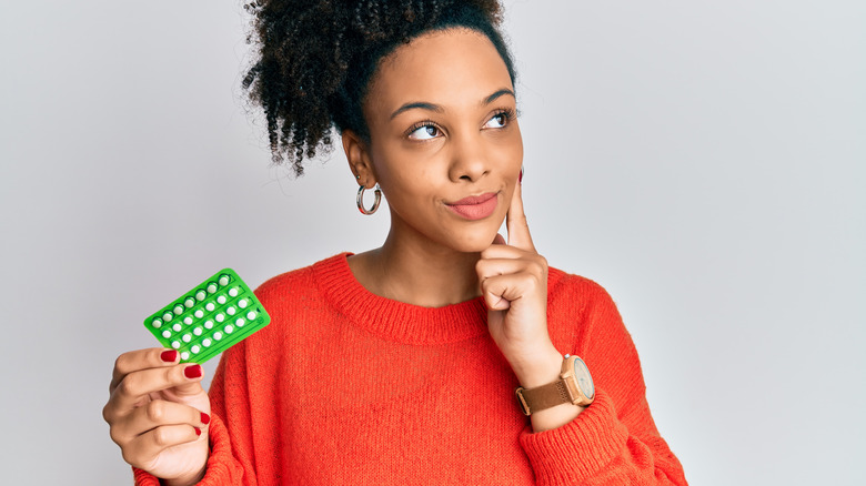 Woman holding birth control pills 