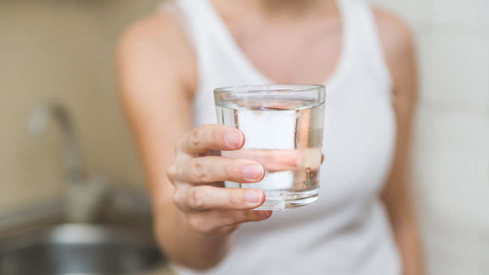 woman holding water glass