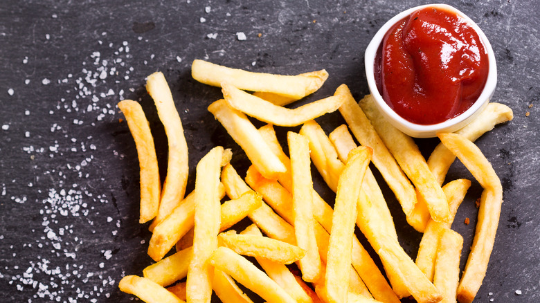 Pile of french fries with salt and ketchup 