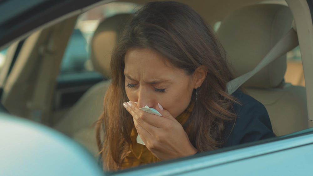 Woman in car feeling sick