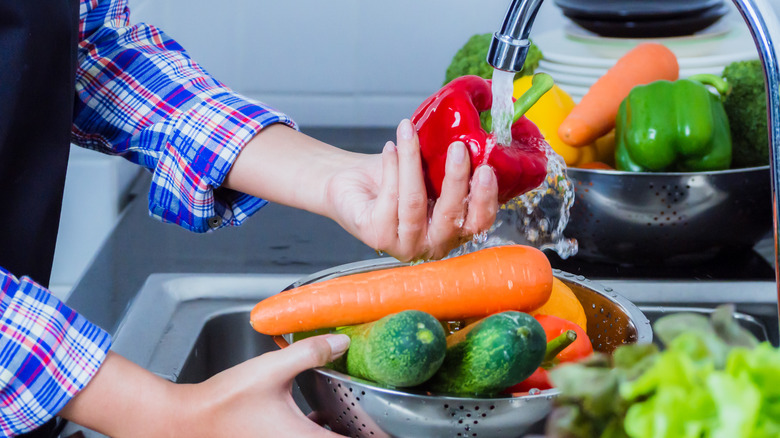 Young woman washing produce to remove pesticides