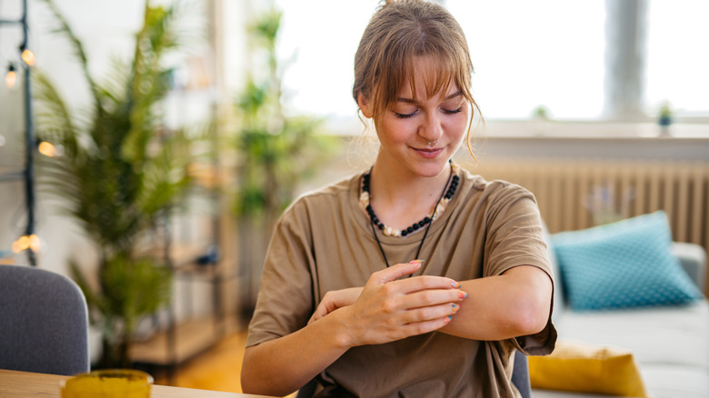 woman with ezcema scratching arm
