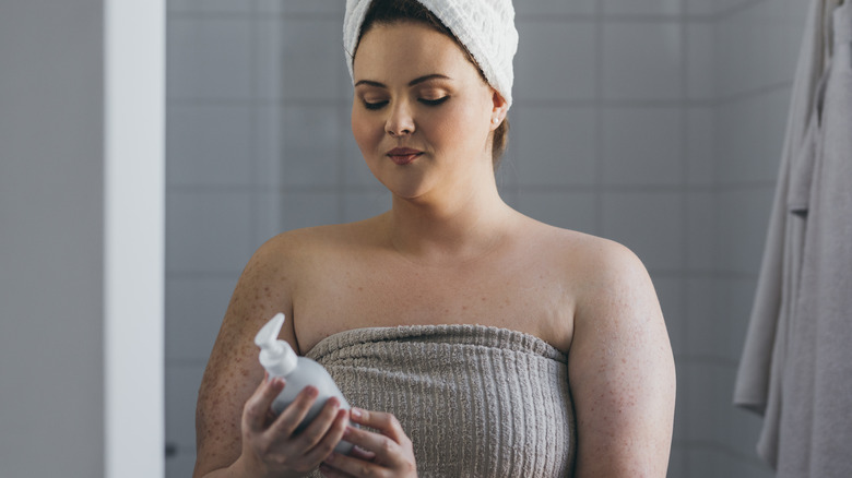 Woman looking at shampoo bottle