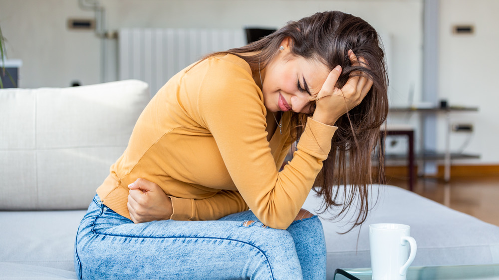 Woman leaning over with stomach ache