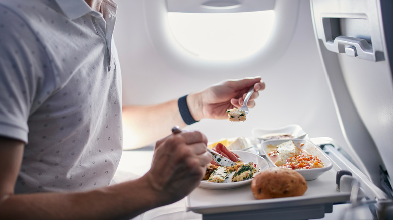 Man eating food on plane