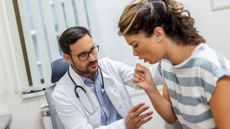 woman in doctor's office coughing