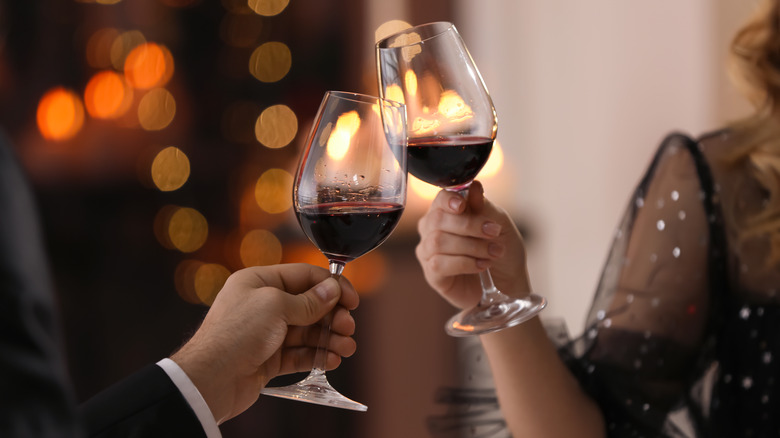 Two people toast with glasses of wine