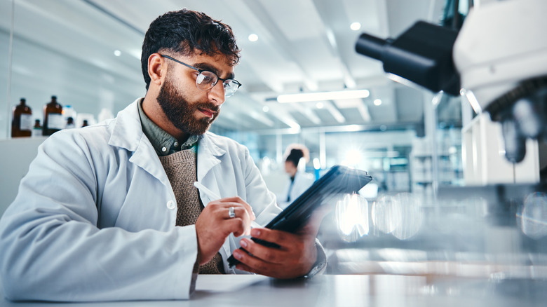 scientist studying data on a device in laboratory