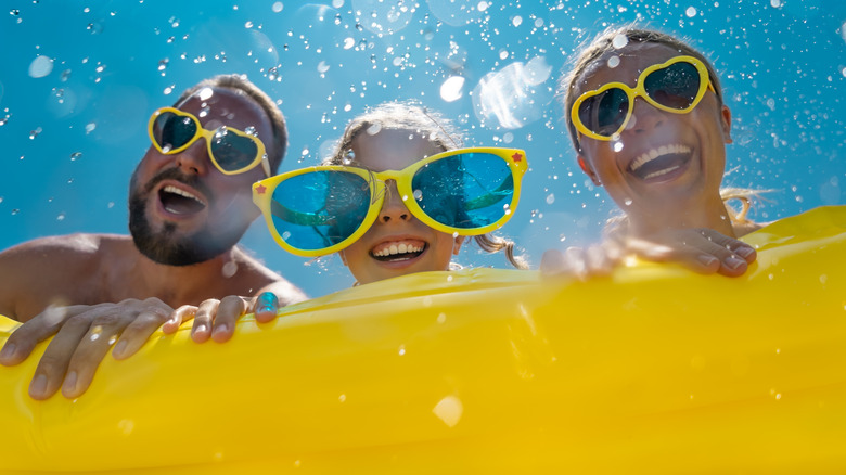 Three people having fun in a pool 