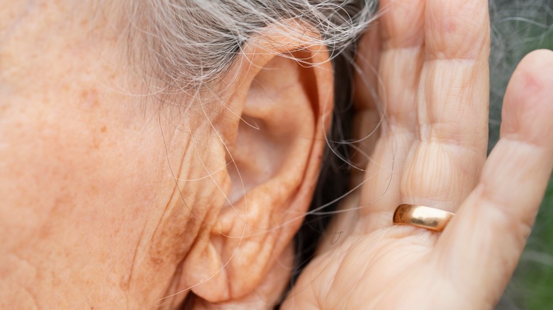 Older adult placing hand next to ear