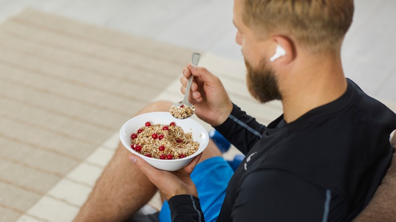 man eating a bowl of oatmeal with berries