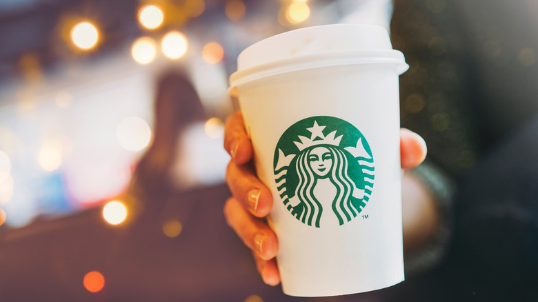 Woman's hand holding Starbucks cup