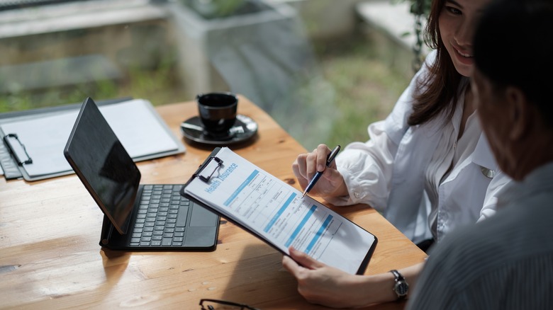 Health professional shows patient a health insurance form