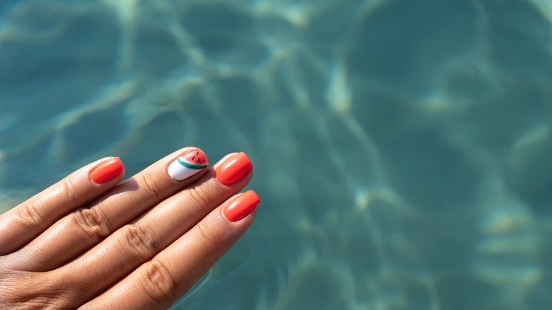 beautiful nails by a crystal clear pool