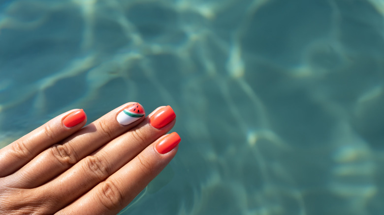 beautiful nails by a crystal clear pool