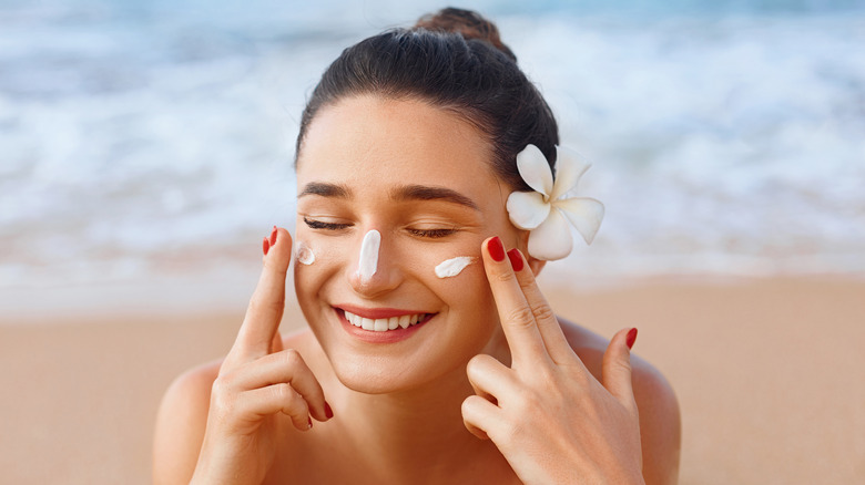 Woman putting on sunscreen