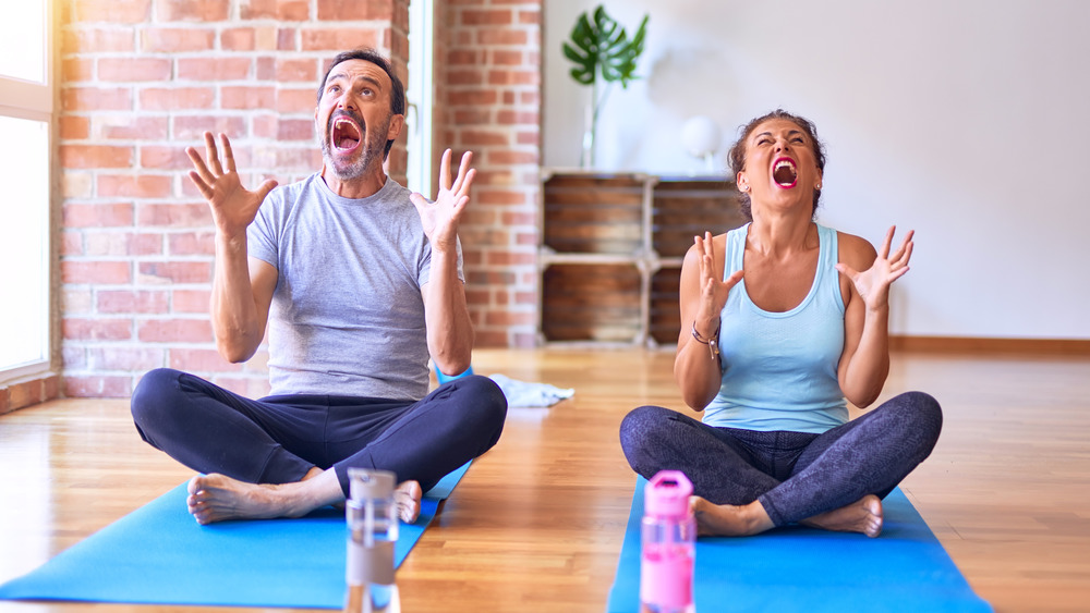 Two people yelling in rage on yoga mats