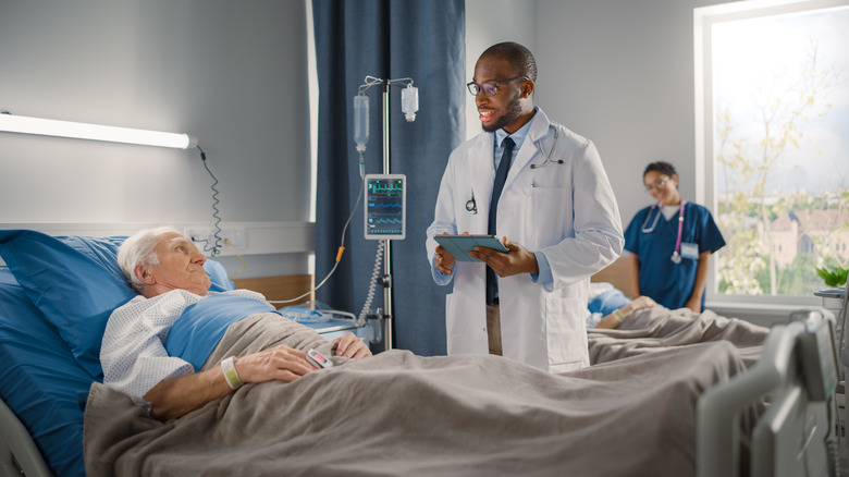 A doctor talks to a man after surgery