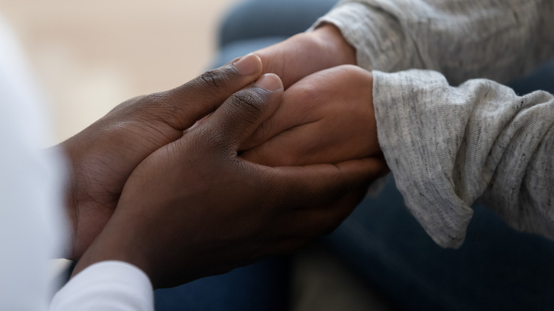 Close up on two pairs of holdings hands
