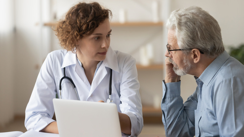 doctor talking to elderly man