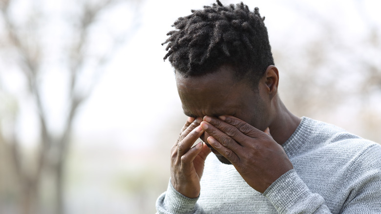 A man rubbing his eyes