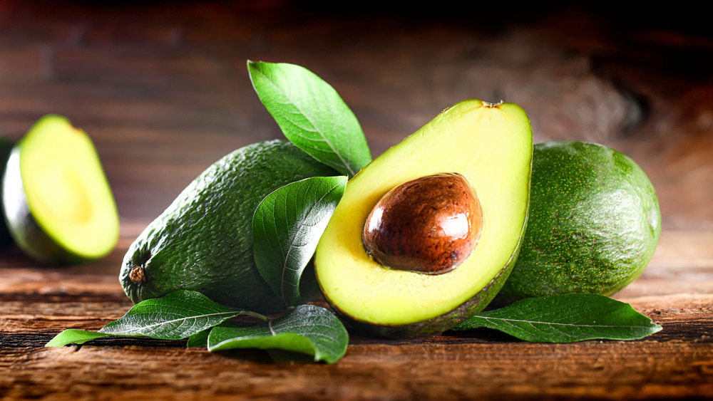 Cut avocados on wooden table