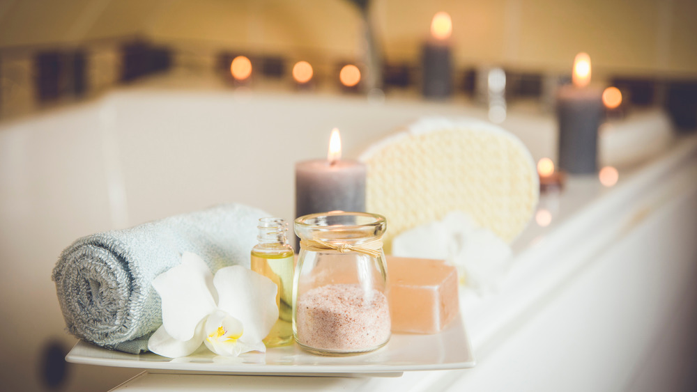 A bathtub with candles, soap, salts, etc.