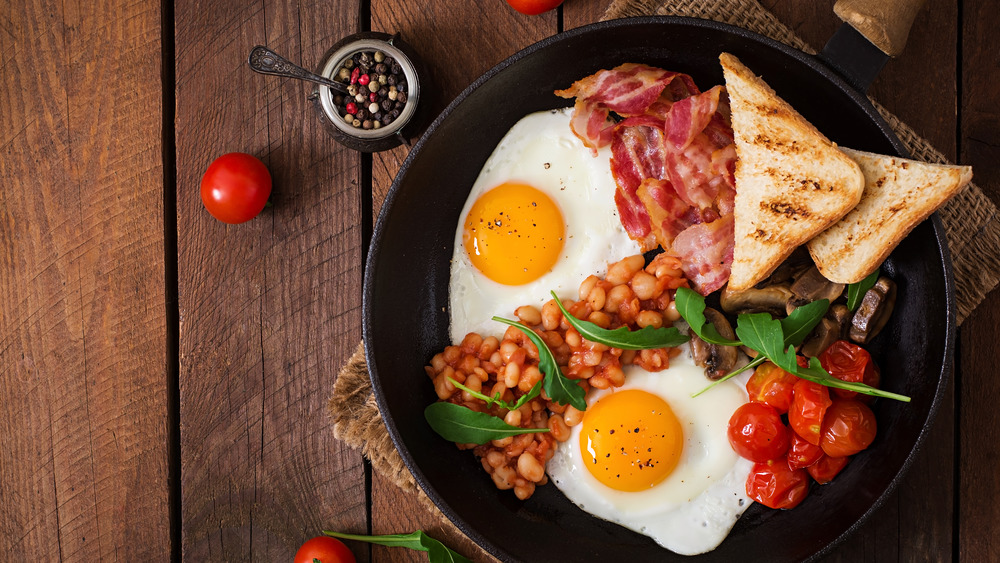 A traditional English breakfast with toast, eggs, tomatoes, and mushrooms