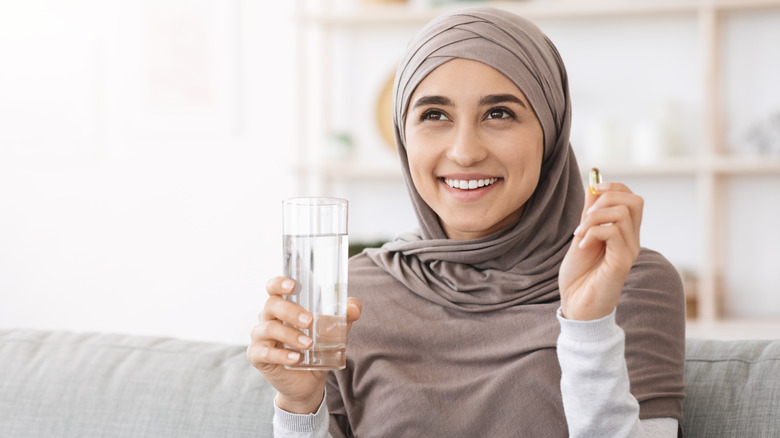 woman holding a vitamin