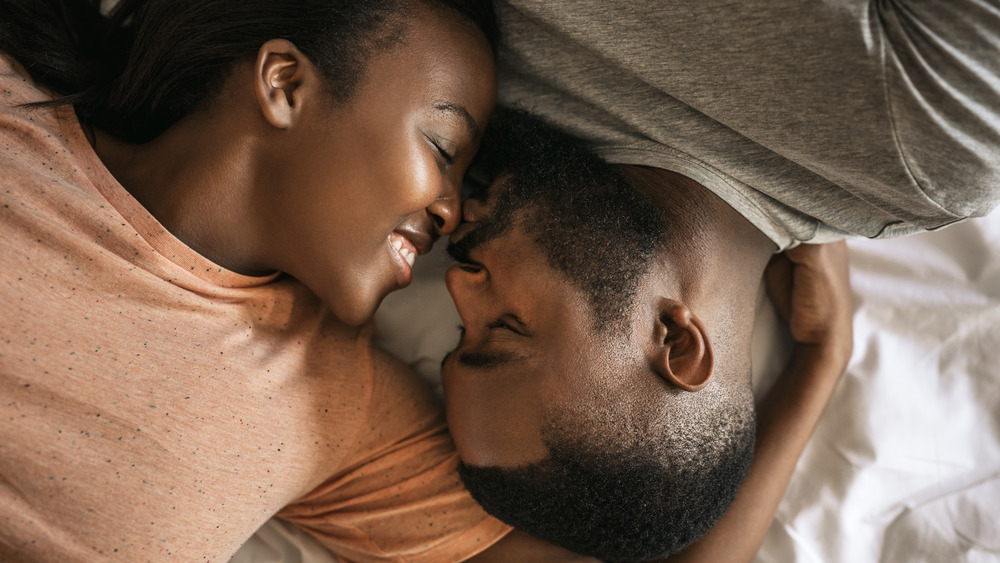 Close up of a couple's faces as they lay in bed