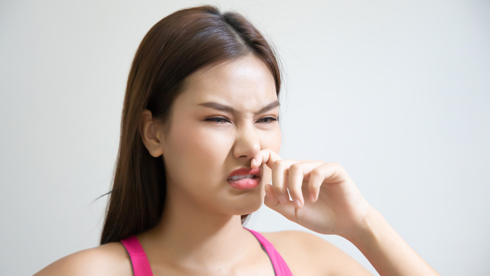 woman smelling something stinky