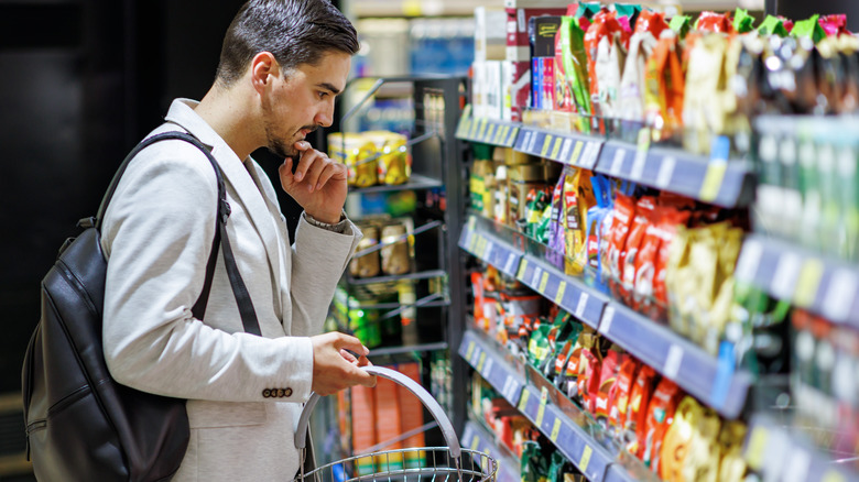 man looking for snack options at a convenience store