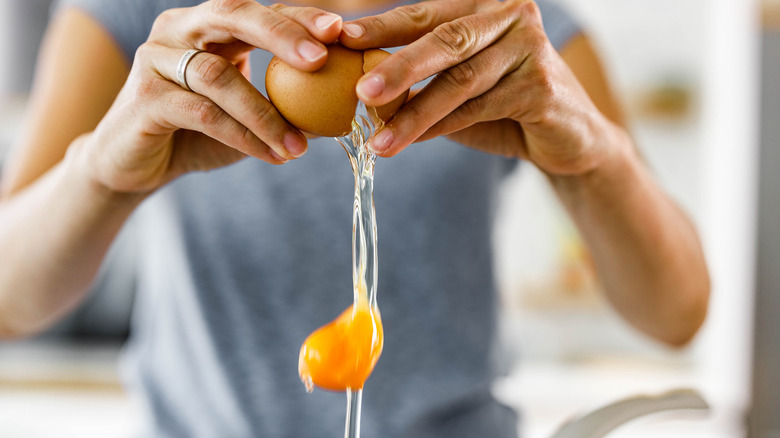woman cracking egg into bowl