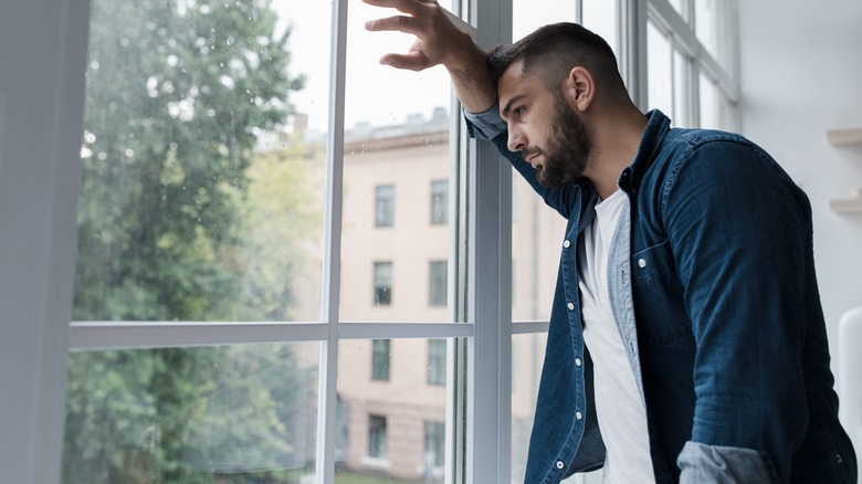 Man looking out window