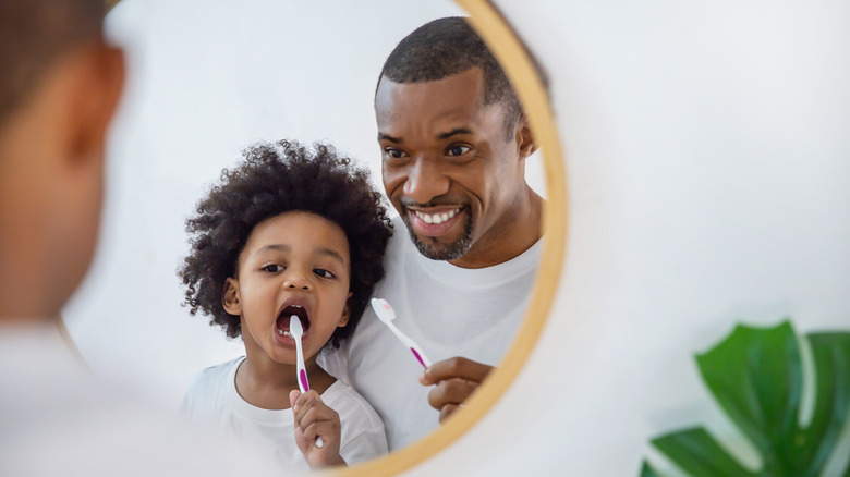 Father and child brushing teeth