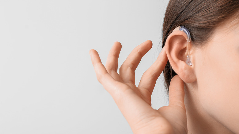 A woman wears a hearing aid