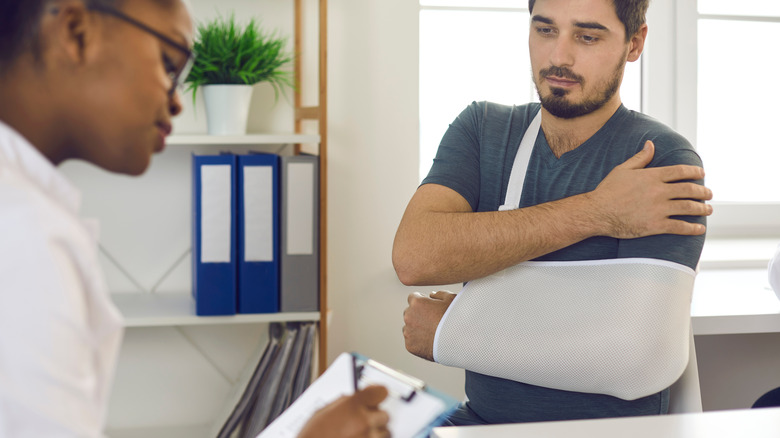 doctor seeing patient with broken arm