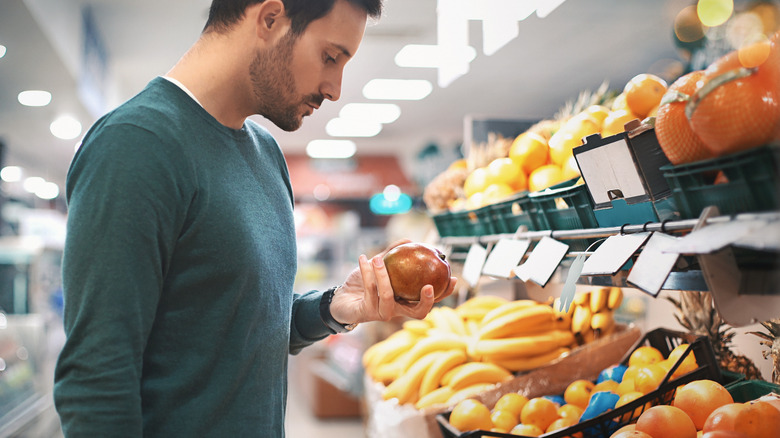 man choosing yellow and orange fruits