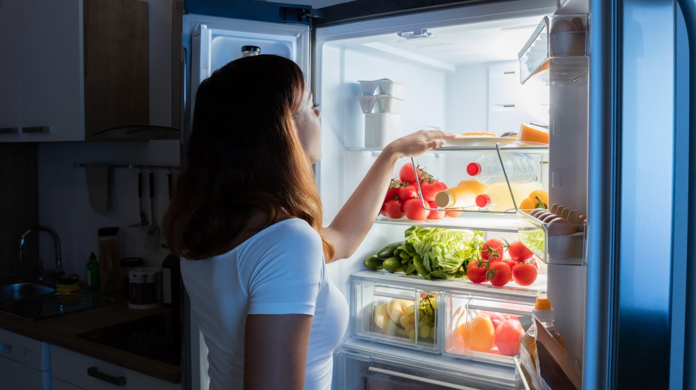 woman looking in fridge at night